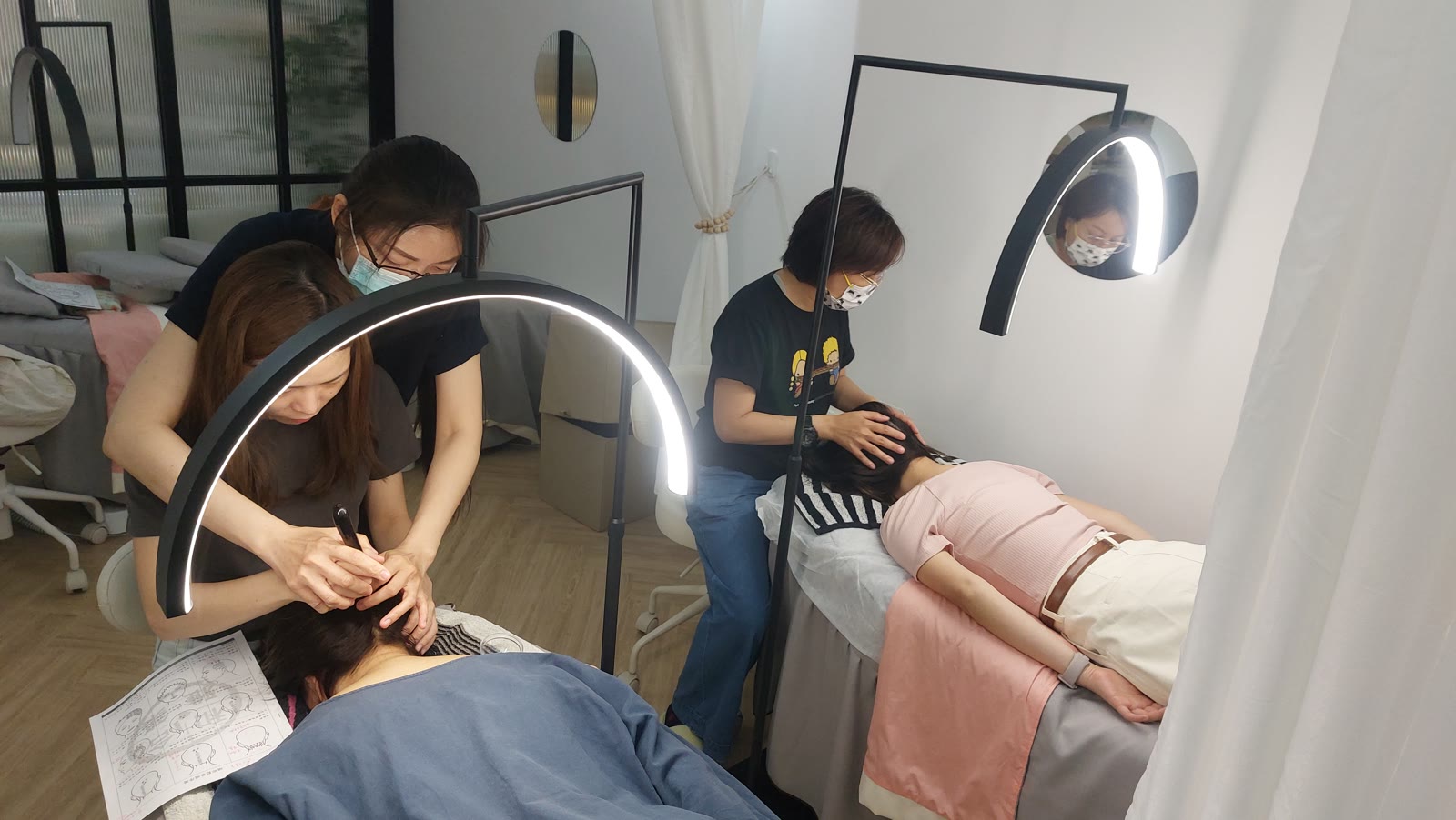 A bojin instructor guiding a student through a hands-on eye-area technique in a small class