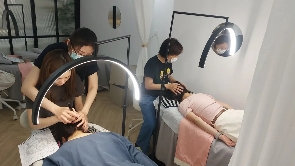A bojin instructor guiding a student through a hands-on eye-area technique
