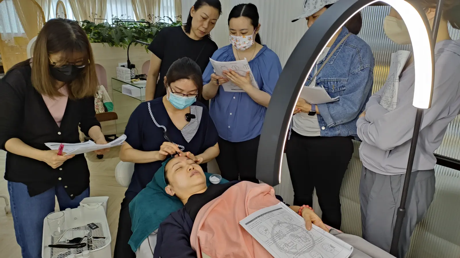 A bojin tool held in hand while demonstrating an eyebrow-area technique to a small group