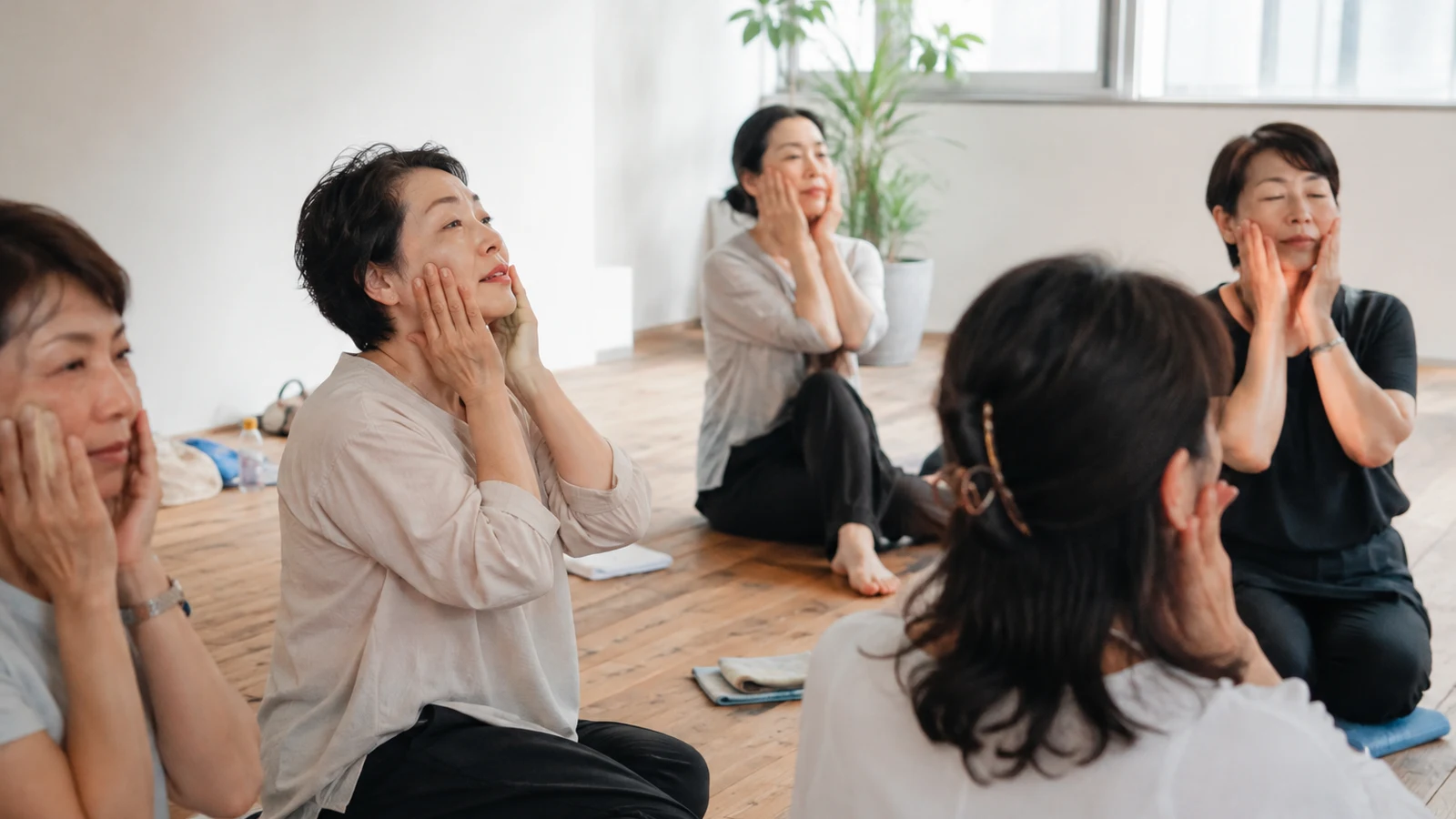 A small group of women practicing a gentle bojin technique together in a bright studio
