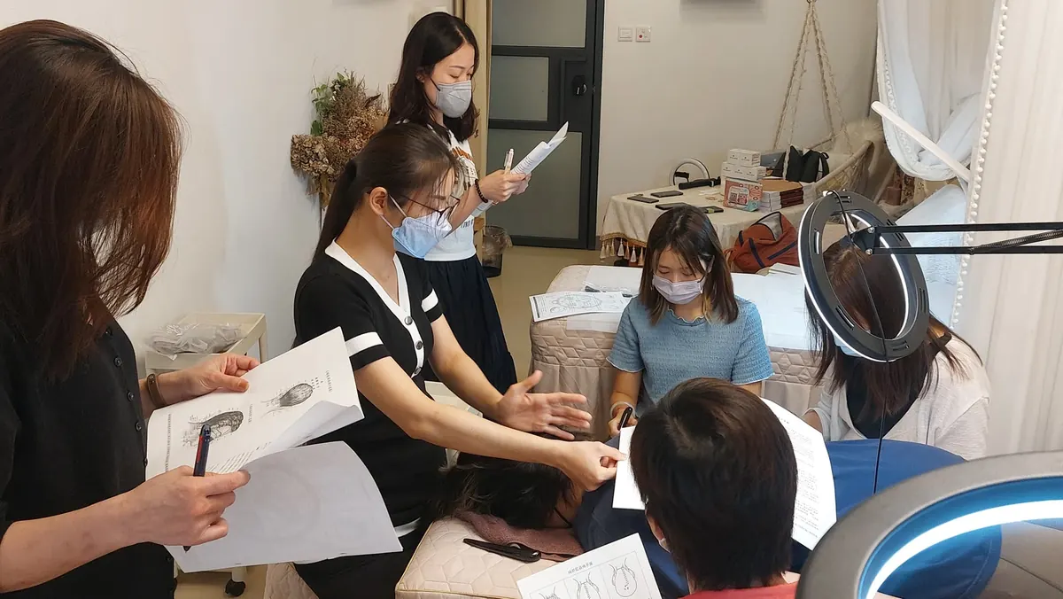 A bojin instructor gently reading a woman's face before showing her a calm, careful technique.