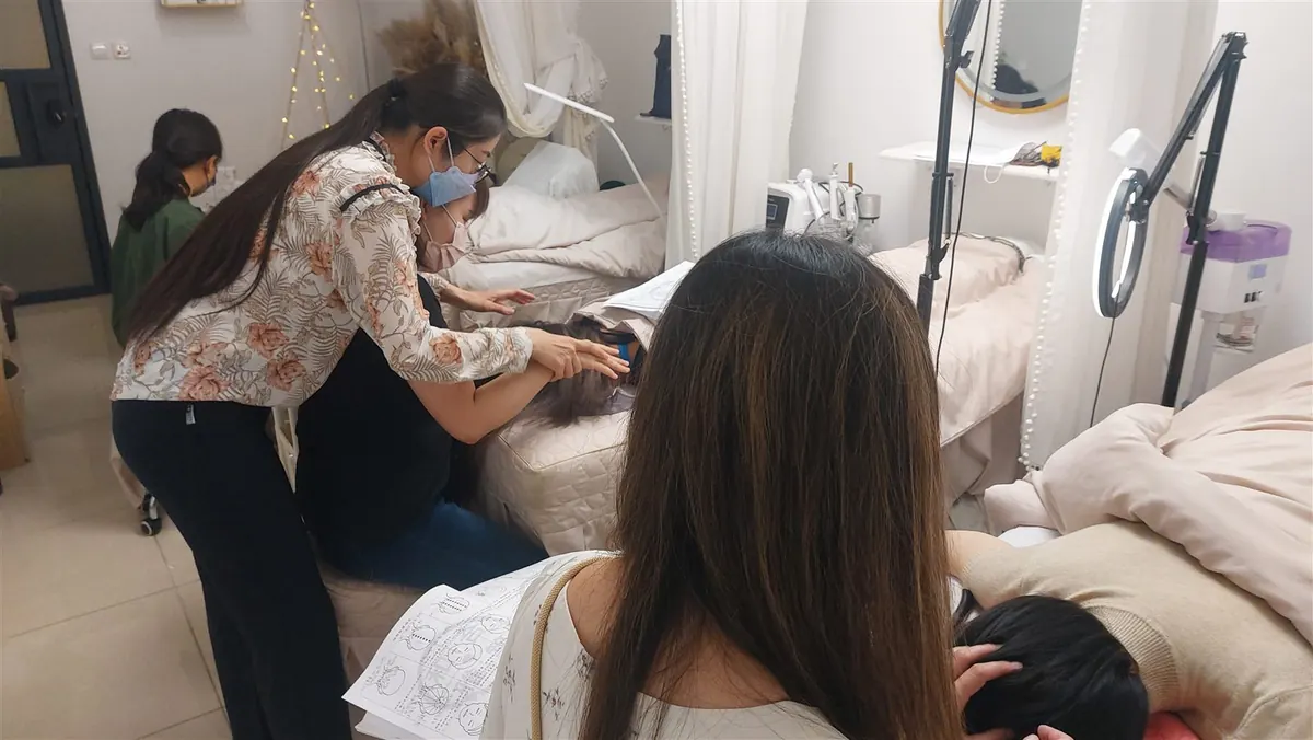 A bojin instructor laying out a stainless steel stick and a small bottle of facial oil before a gentle studio lesson.